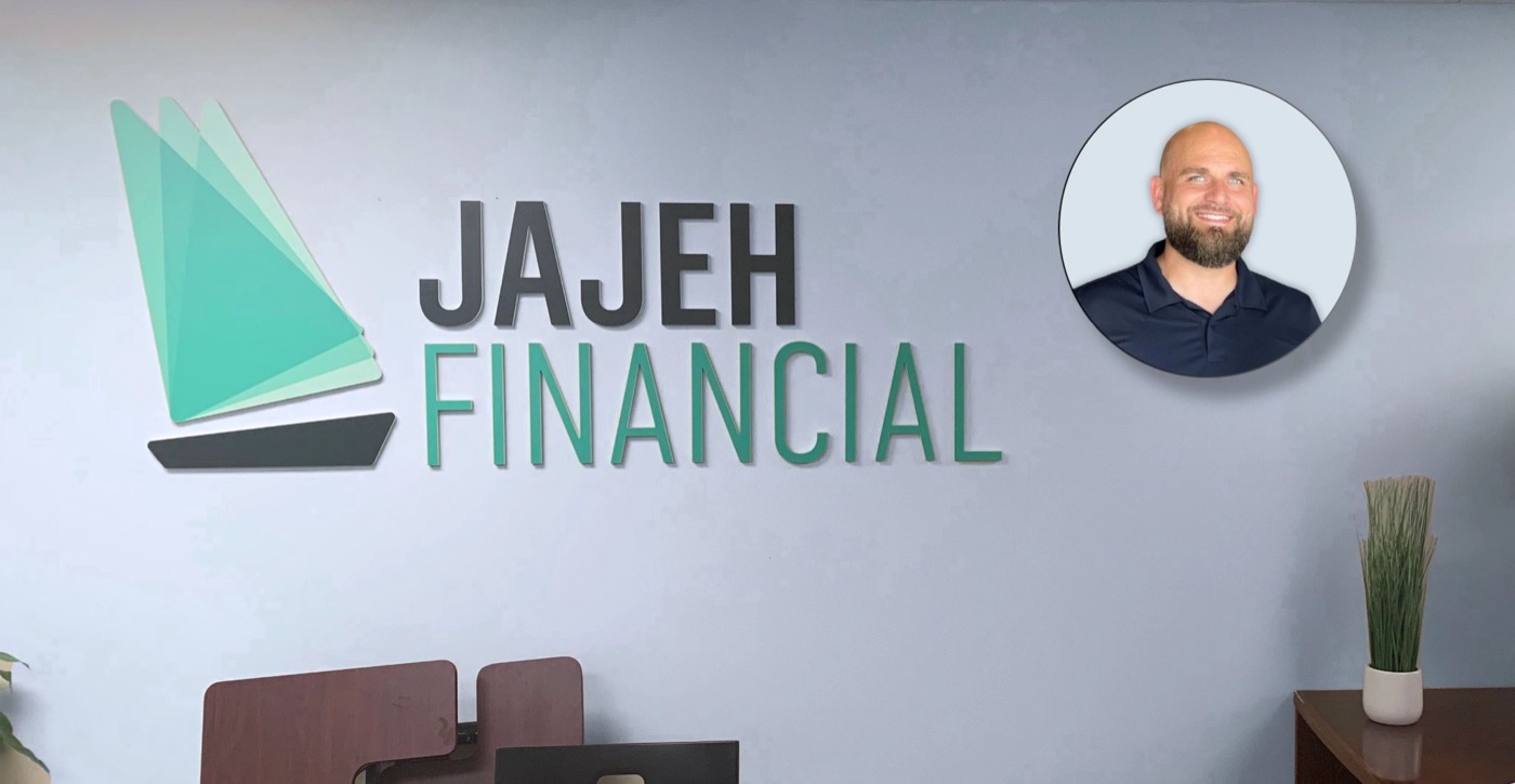 Jajeh Financial office wall with logo, and a portrait of Patrick K Currie